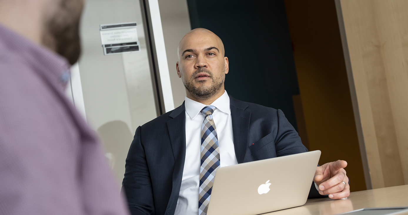 a person in a suit in front of a laptop