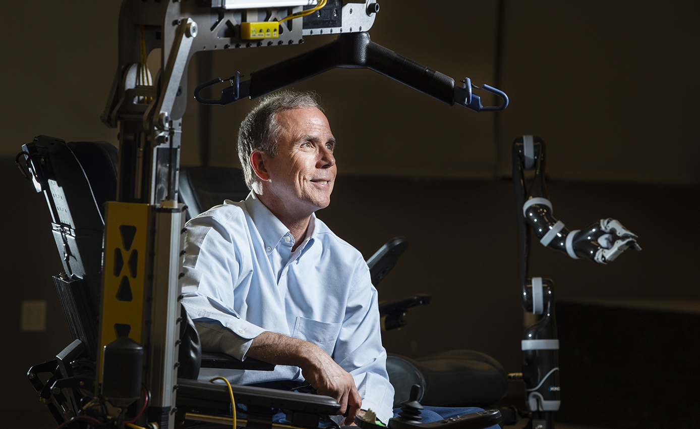 Cooper inside of one of his inventions—a robotic arm bending over his head