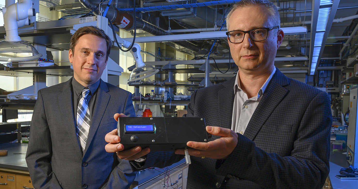 Associate professor of electrical and computer engineering Ervin Sejdic, left, and professor of chemistry Alexander Star show the prototype of the THC Breathalyzer developed using their interdisciplinary research. 