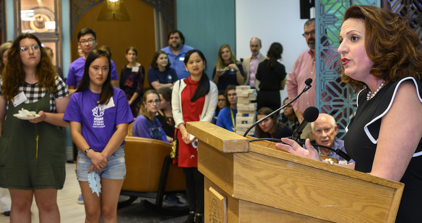 Belkys Torres at a podium speaking to a group of students and others