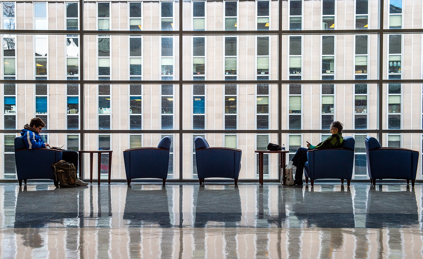 two students in chairs at the Pete with Alan Magee Scaife Hall looking geometric in the background