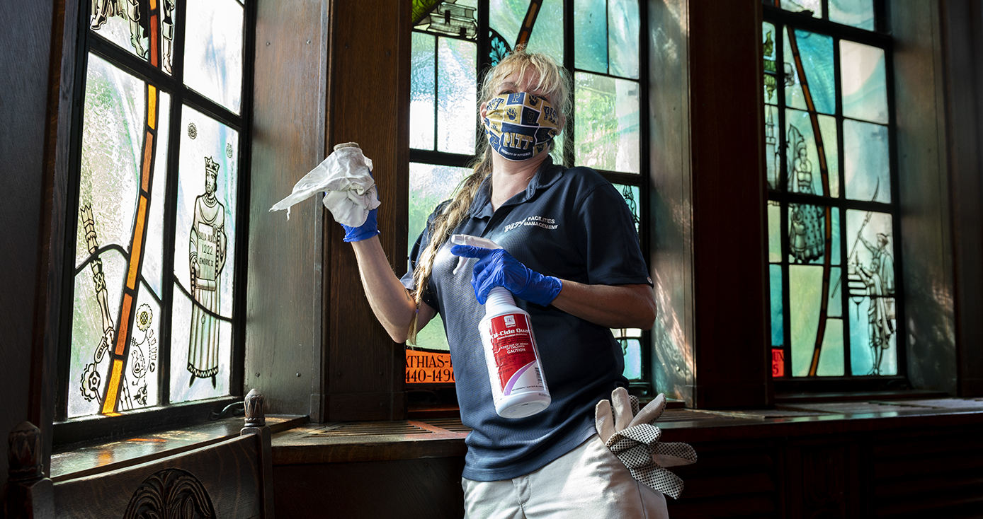 Ruth Mullen in a blue shirt and holding a spray bottle with a rag