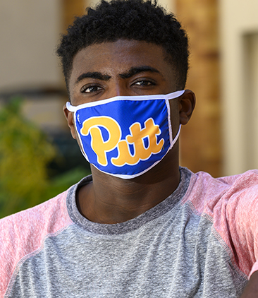 A man in a pink and gray shirt with a Pitt face mask