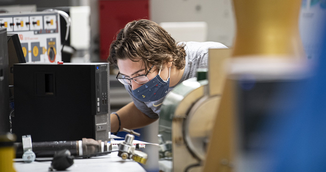 A person in a face mask operates in a lab
