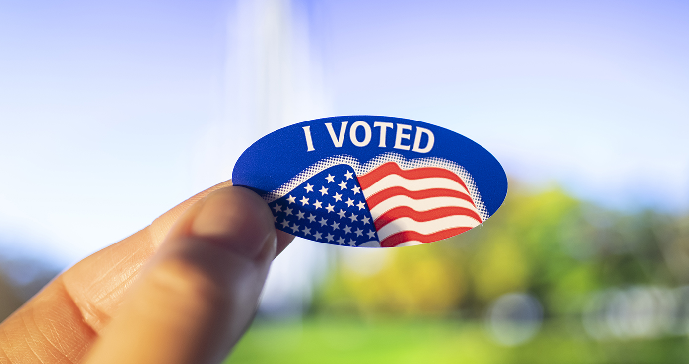 A hand holding an "I Voted" sticker