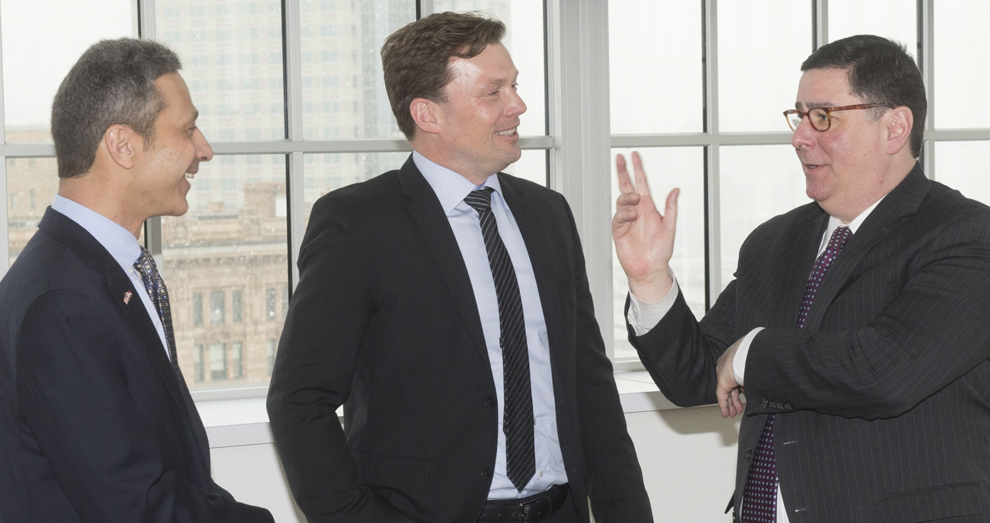 three men in suits talking