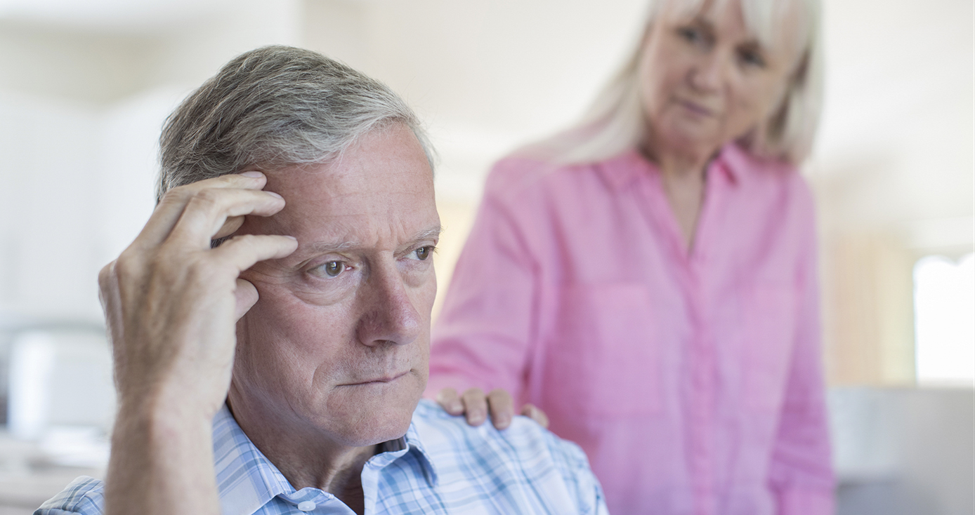 a man in a blue and white shirt holding his fingertips to his head