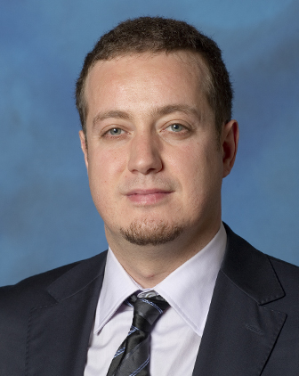 Headshot of Murat Akcakaya, against a blue background.