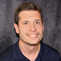 Bost in front of a gray background in a dark shirt