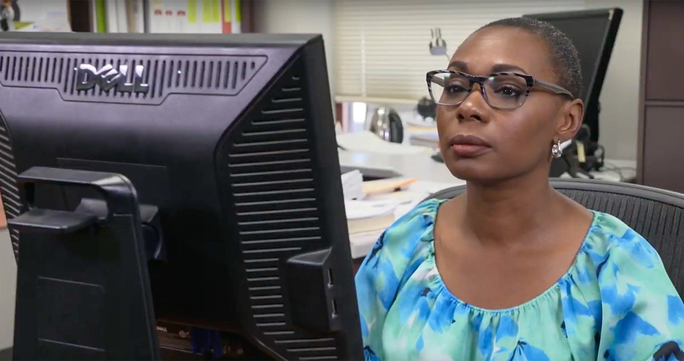A person in a blue shirt on a computer