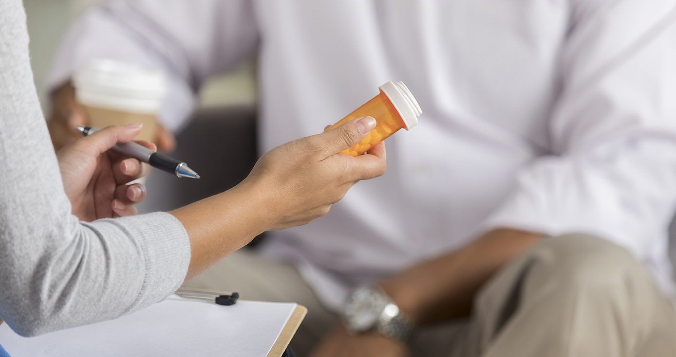 A physician holding a bottle of pills