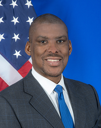 Hogan in front of a blue background and an American flag