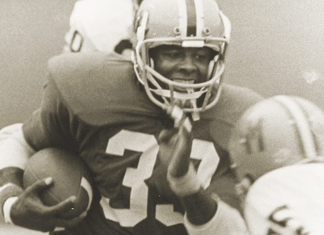 Tony Dorsett running while holding football