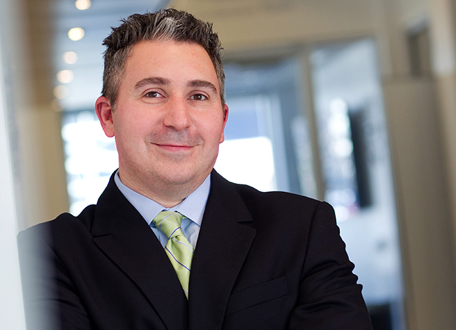 Evan Facher headshot in suit jacket shirt and tie