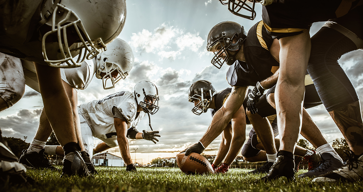 Two football teams facing off on the line of scrimmage