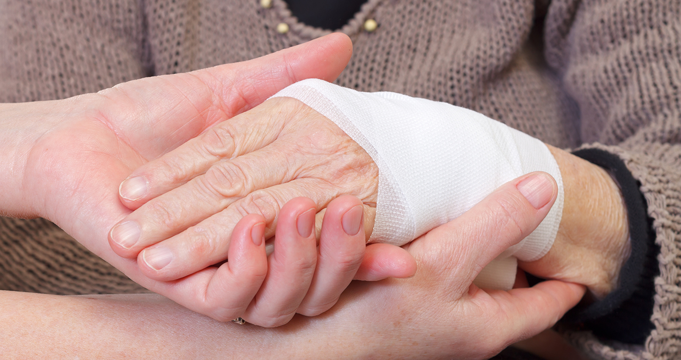 a person holding another person's bandaged hand