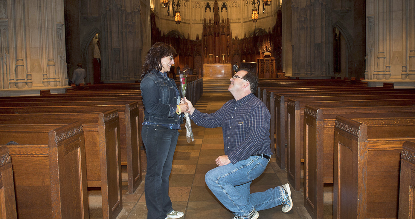 man on knee holding a rose up to a standing woman