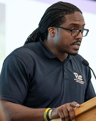 Idoko in a navy polo at a podium