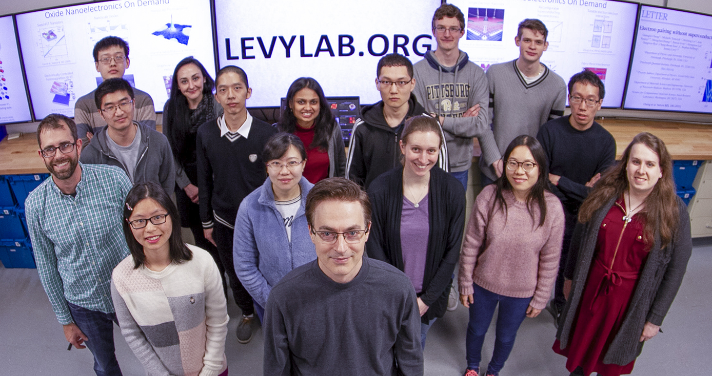 Jeremy Levy, a Distinguished Professor of Condensed Matter Physics in the Department of Physics and Astronomy, stands in front of his team in Levy Lab. 