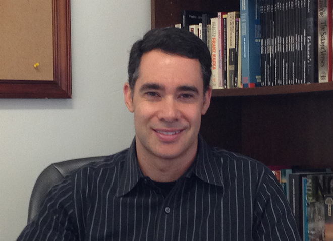 Adam Lowenstein in front of bookshelf