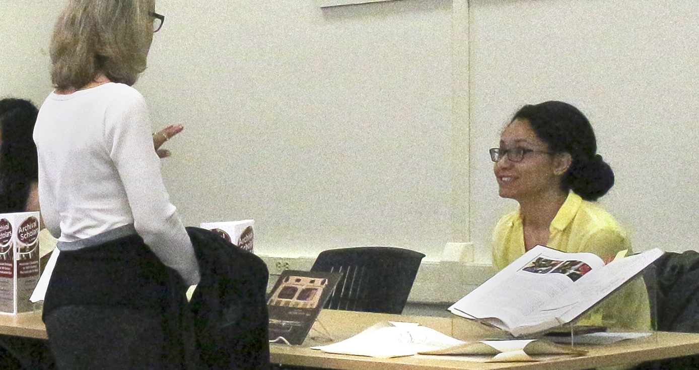 Gabriella Galli seated at table with display from her research project