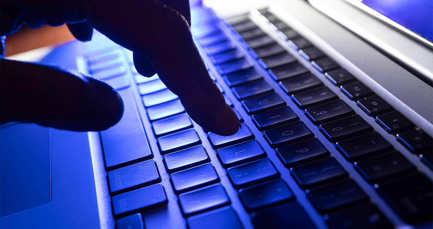 A hand on a laptop keyboard