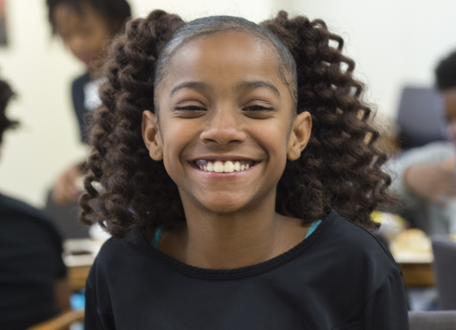 little girl with crimped pigtails smiling