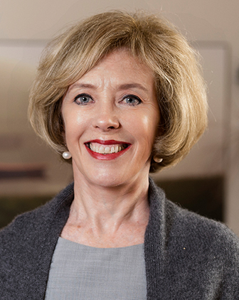 A woman in a gray shirt and sweater