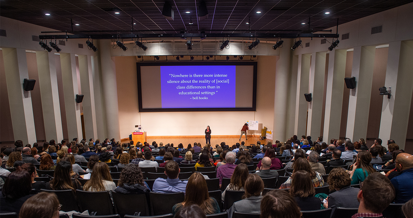 In the Rangos Auditorium at Carnegie Melon University. A crowd listens to a person on stage. 