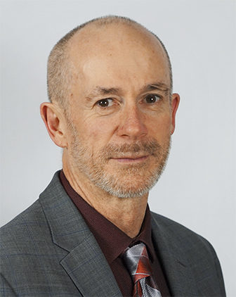 Christopher P. O’Donnell in a gray suit and dark red shirt