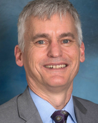 A man in a light blue shirt and gray suit jacket