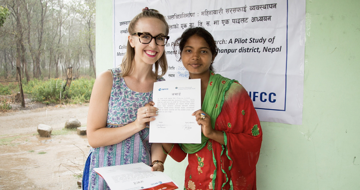 two women standing together holding a piece of paper on either side