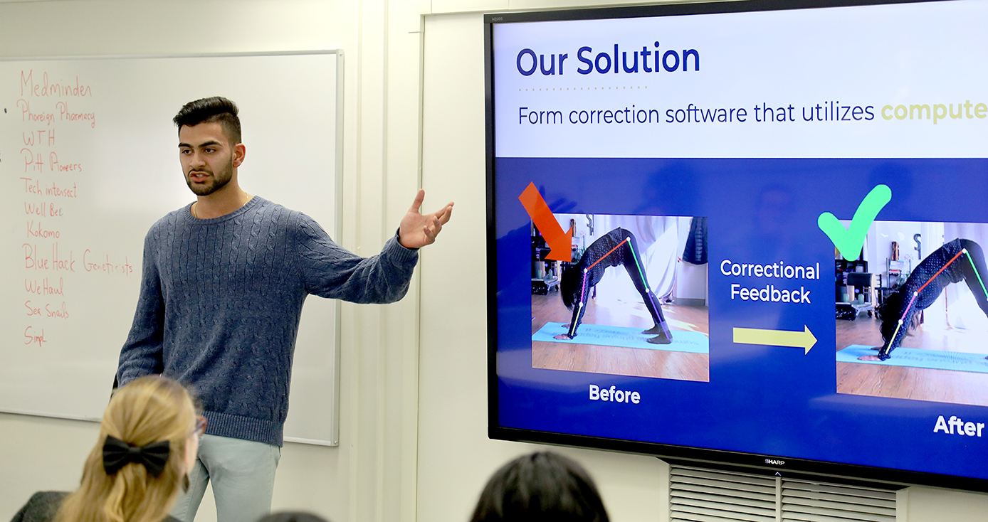 Kunal Gandhi in a blue shirt presenting to a room, pointing to a slideshow displaying the usage of his app