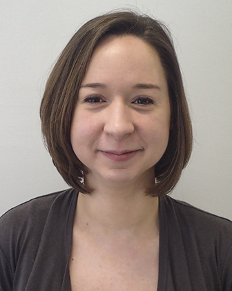 a woman with chin-length brown hair and a dark sweater