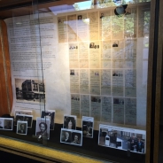 photos and papers arranged in a display case