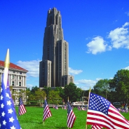 
The Cathedral on a blue sky day with American flags planted in the foreground yard
