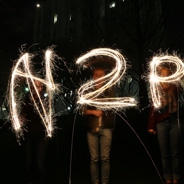 people with fireworks sparklers spelling out H2P in the dark