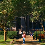 A student walking on a sidewalk