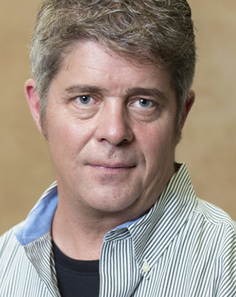 Mark Schmeler in a patterned dress shirt and black T-shirt