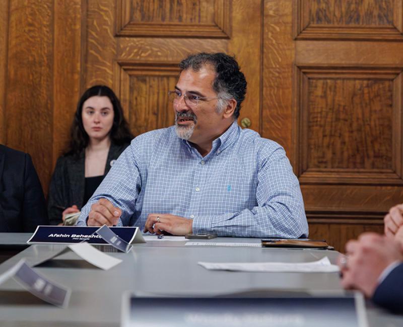 Afshin Beheshti sitting at a table with his name displayed