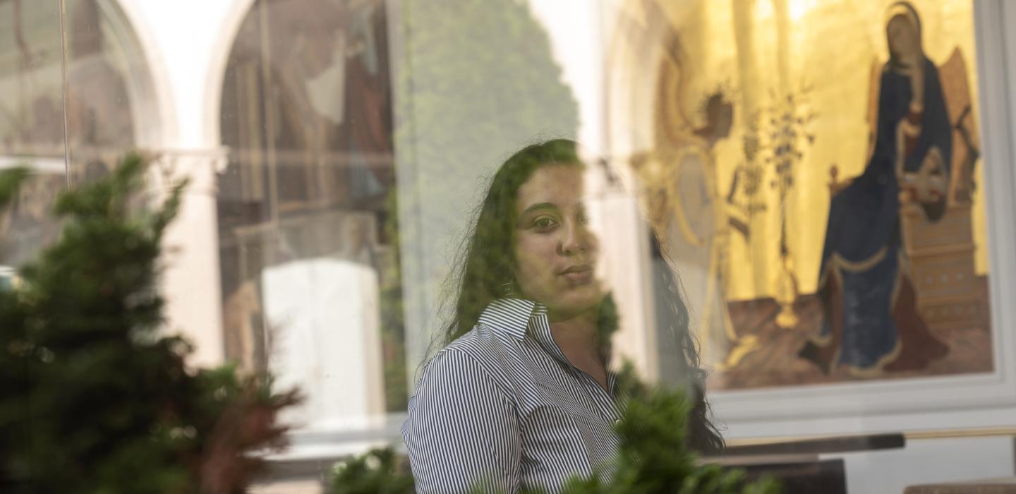 Stephanie Jimenez wearing striped shirt, artwork in the background