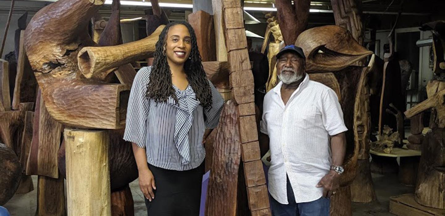 Daren Ellerbee and Thaddeus Mosley standing by wooden art piece