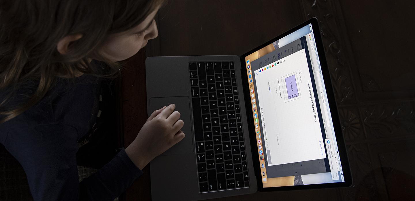 Teen using laptop at a table