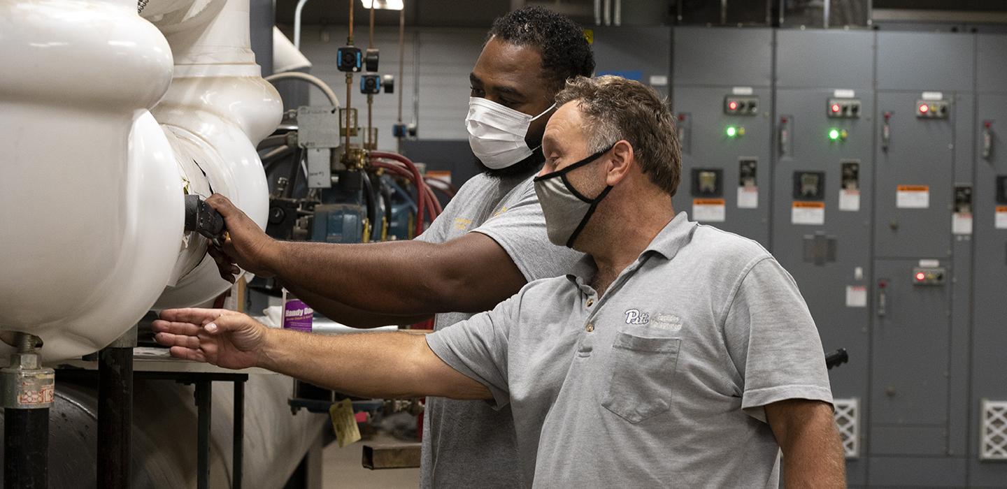 two engineers working together with masks