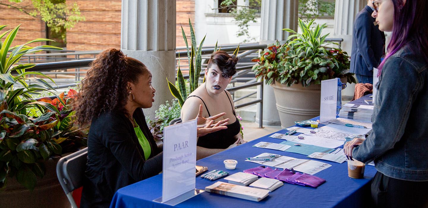 Two people working at an information table discussing PAAR