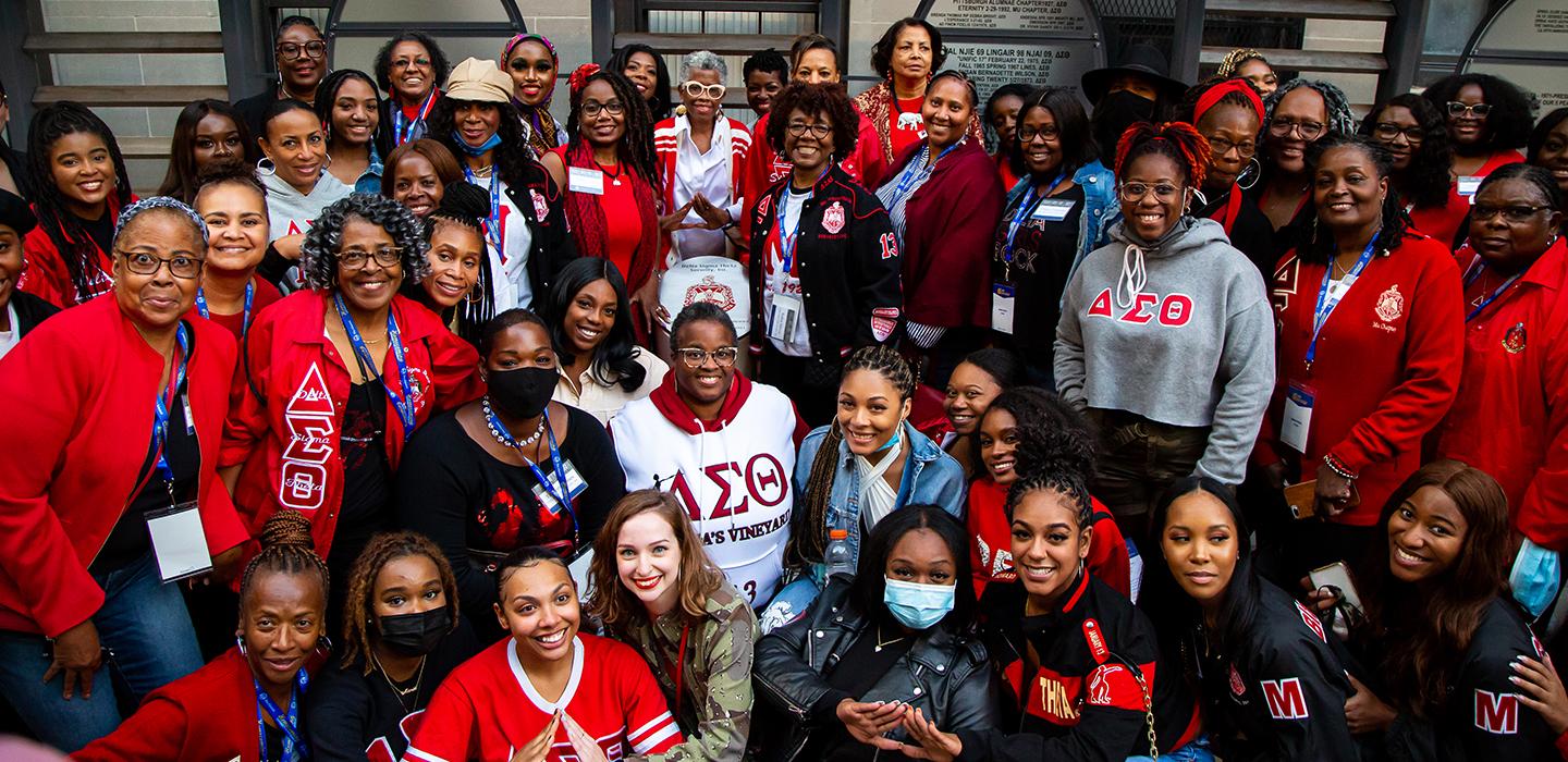 Large group of people wearing red and smiling for photo
