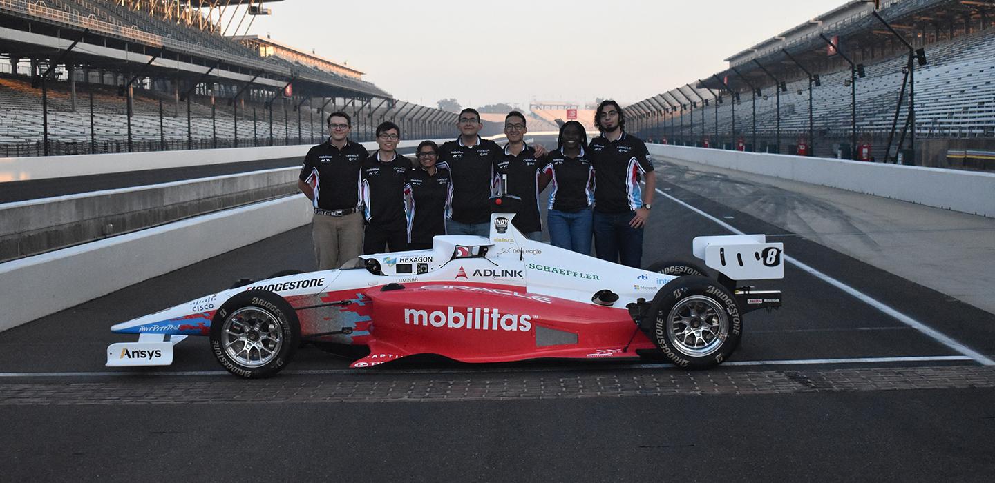 Pitt undergrads at Indianapolis Autonomous Challenge standing next to their car
