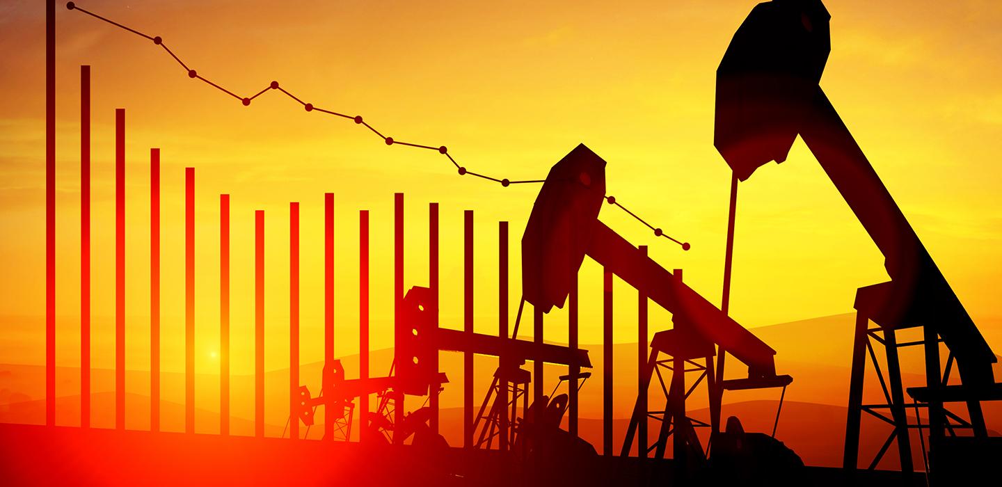 Oil rigs next to a declining graph graphic