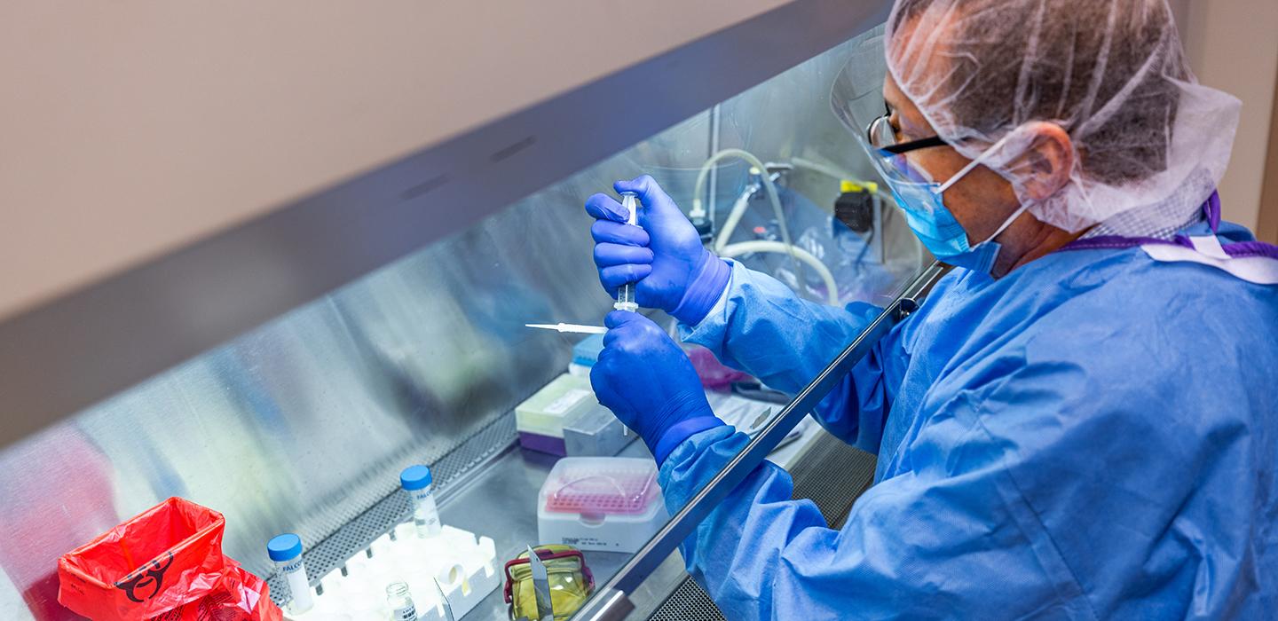 Man in mask handling syringes in lab