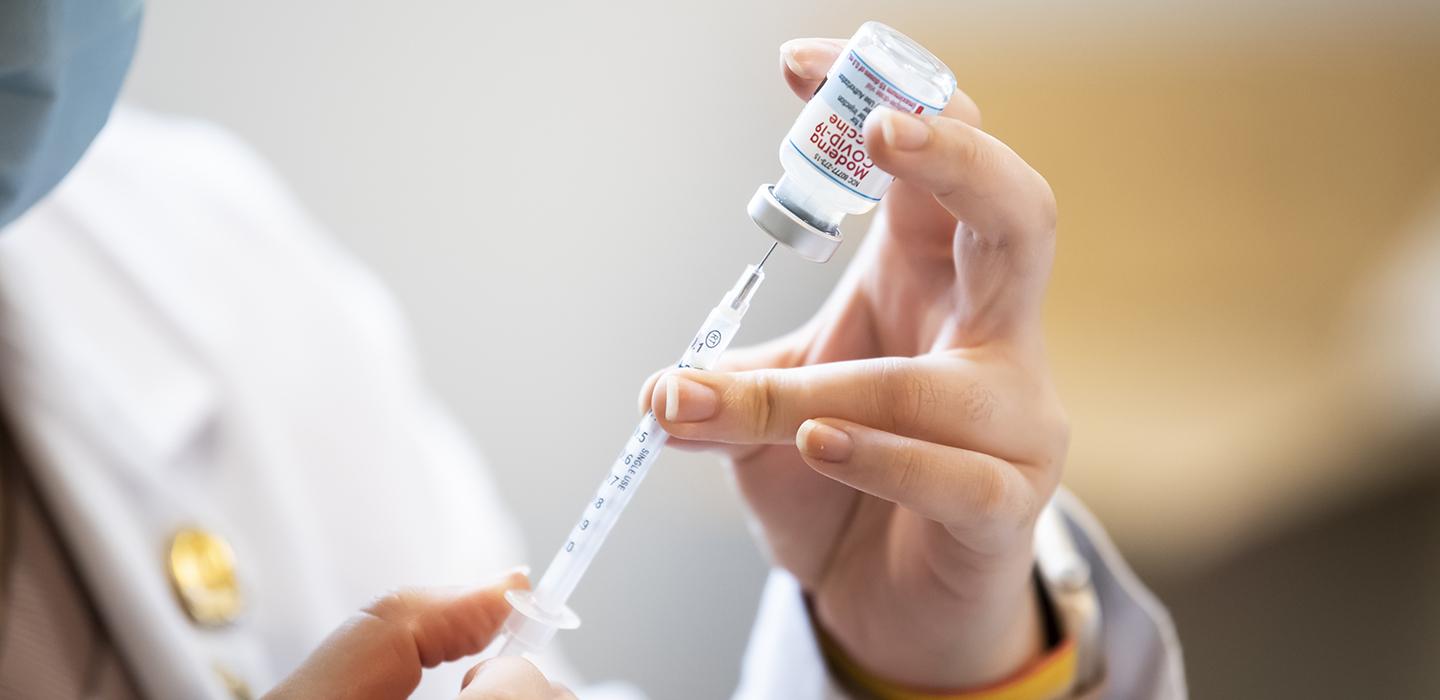 Health professional filling up a syringe 